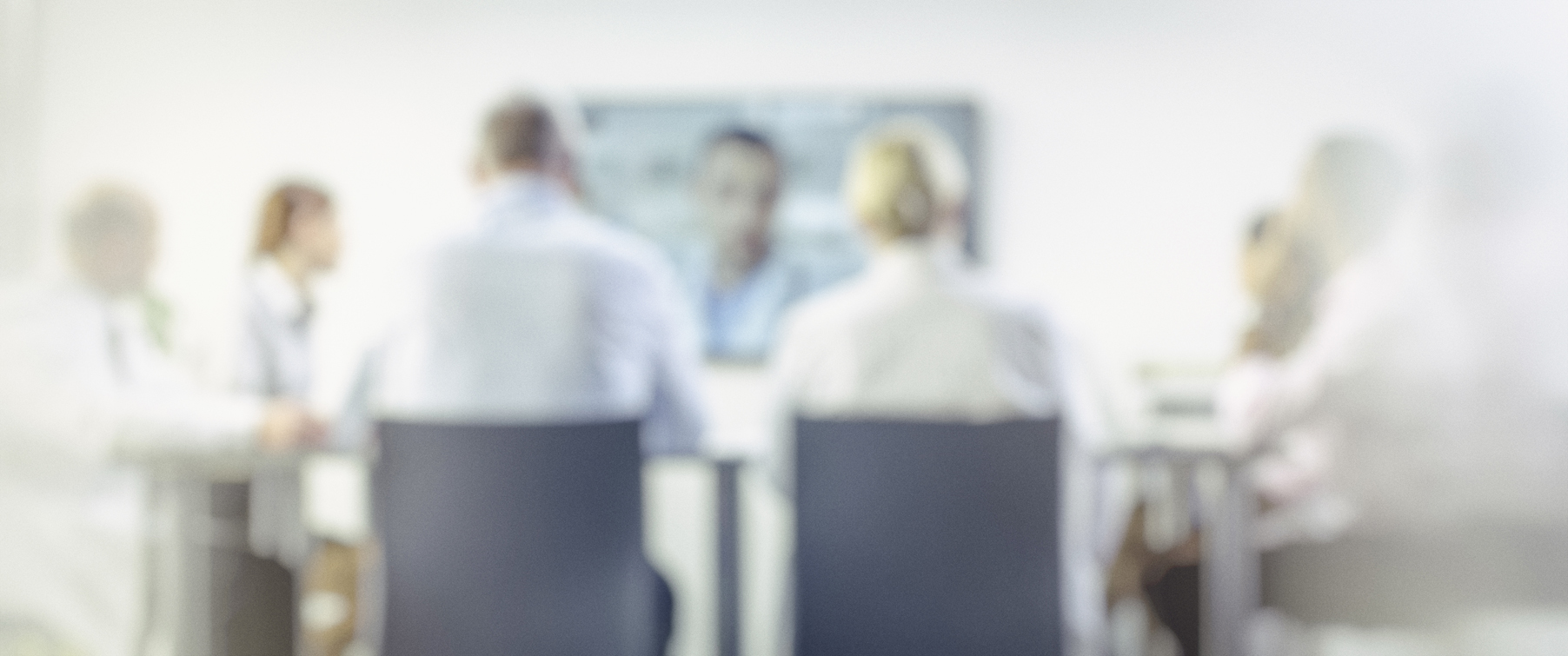 blurred image of 3 people in a meeting