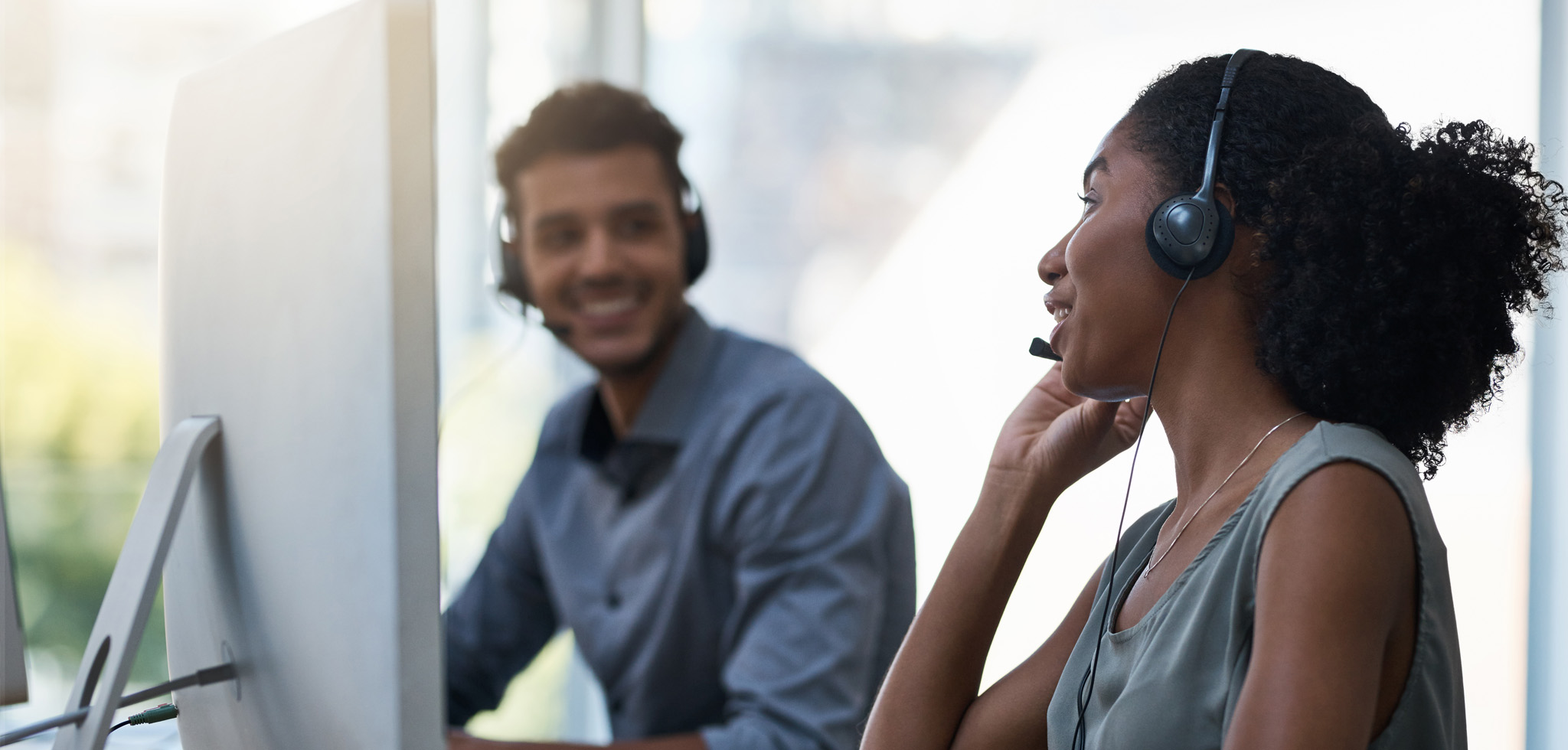 Tierzero Hosted PBX - woman and man with headsets smiling at each other