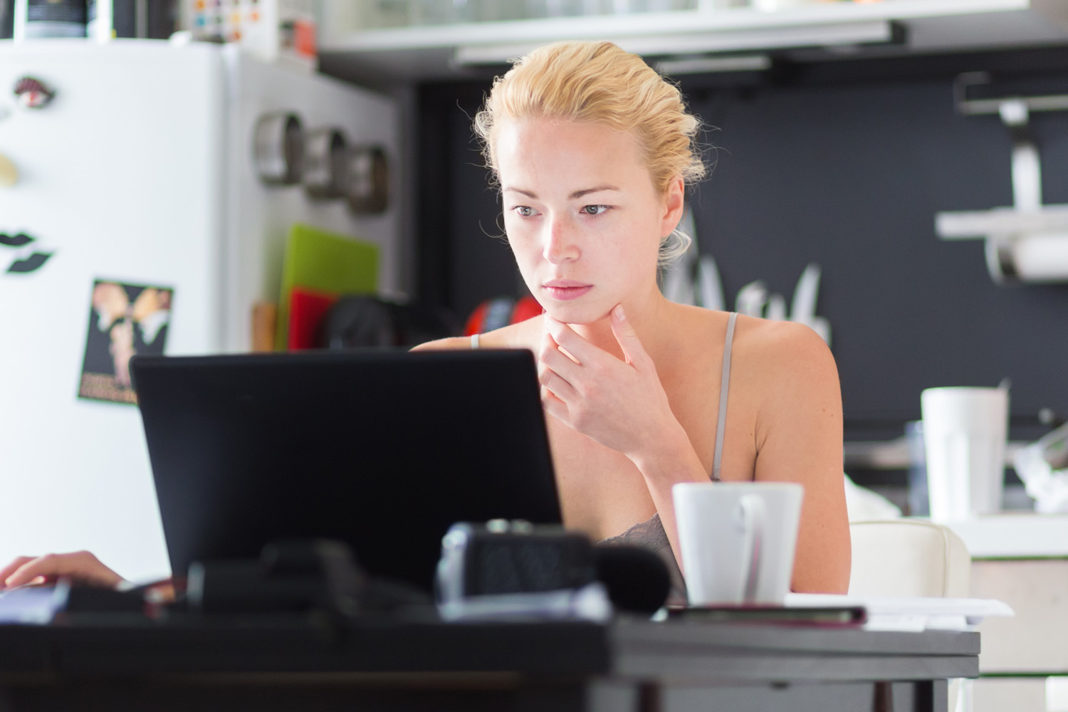 woman in thought looking at laptop device
