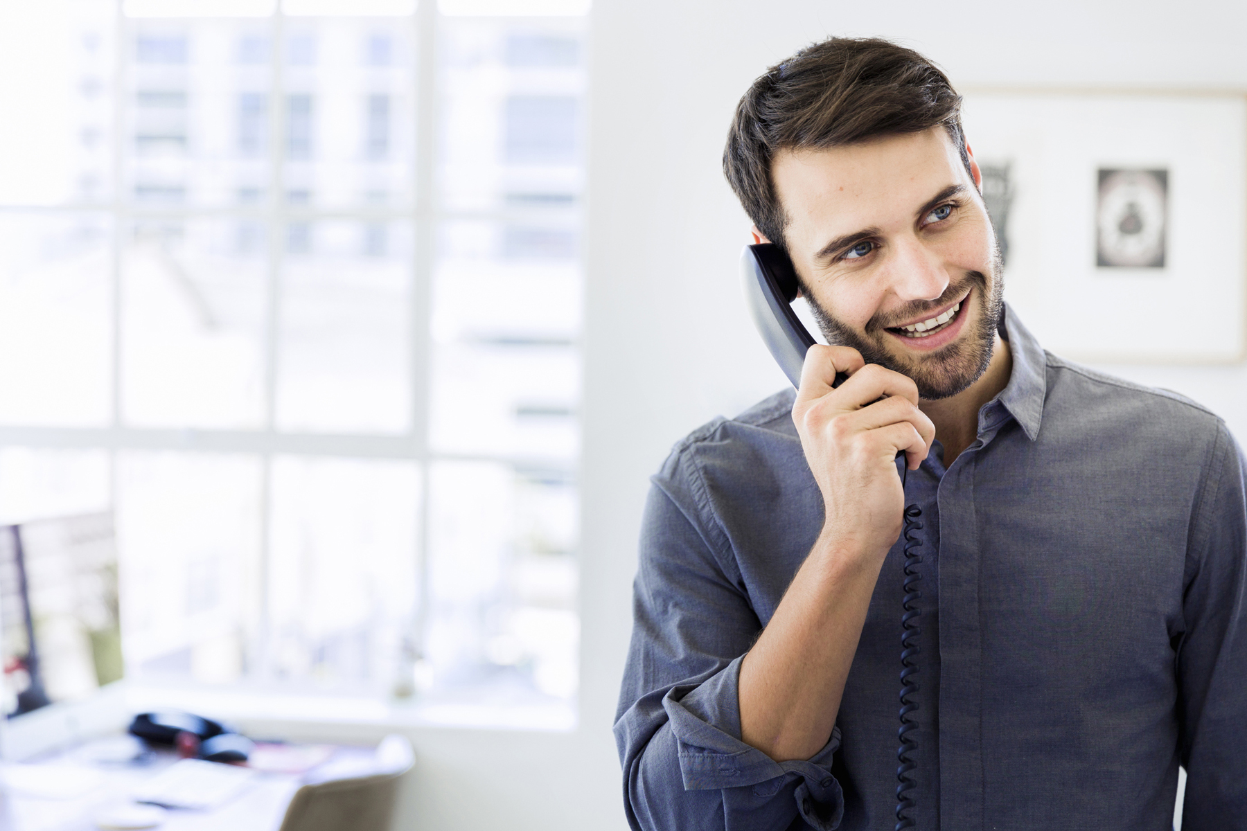 man smiling on phone - happy to save money on his phone bill